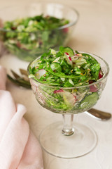 Fresh spring salad in glass bowl on tablecloth
