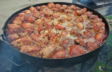 Pork legs stew in a large frying pan. Festival of Ukrainian national cuisine in the open air, Ivano-Frankivsk, Ukraine