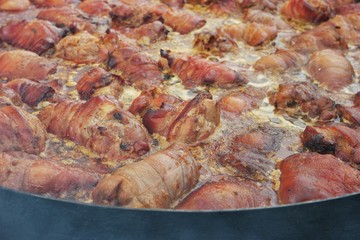 Pork legs stew in a large frying pan. Festival of Ukrainian national cuisine in the open air, Ivano-Frankivsk, Ukraine