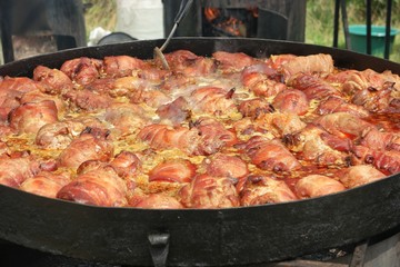 Pork legs stew in a large frying pan. Festival of Ukrainian national cuisine in the open air, Ivano-Frankivsk, Ukraine