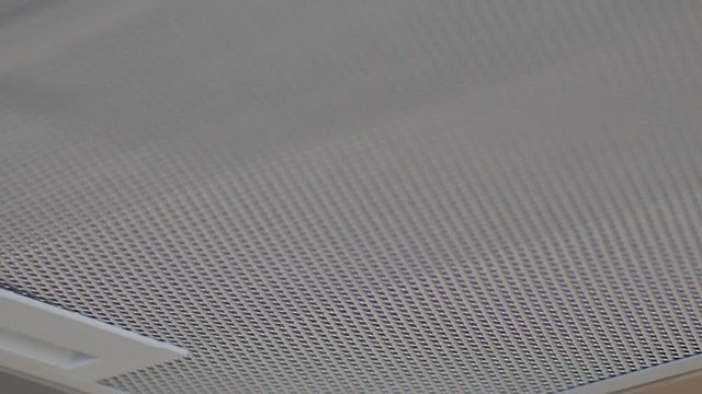 Extreme close up of a modern silver hood fan for ventilation in a kitchen above the stove