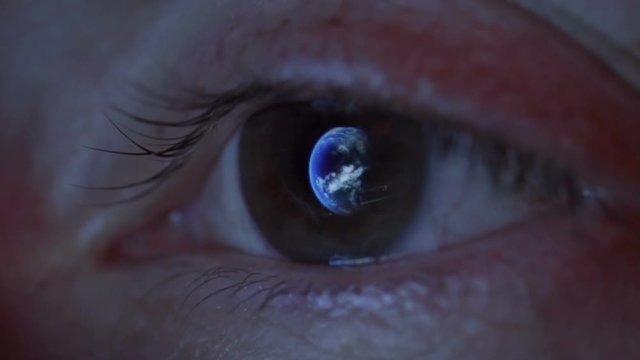 Close up of woman's eye with the earth reflecting in the iris