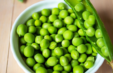 Green pea in bowl on a wooden background