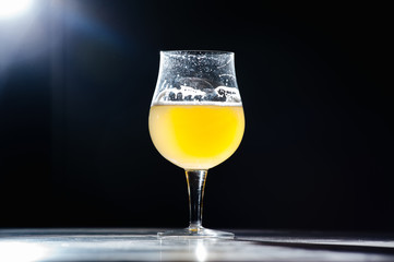 Glass beer with foam on black background with copyspace