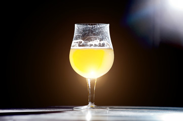 Glass beer with foam on black background with copyspace