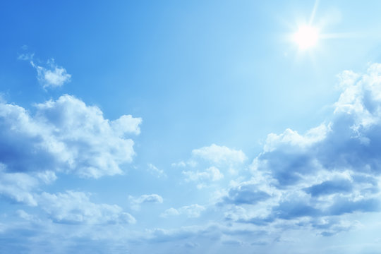 bright blue sky with sun and clouds background