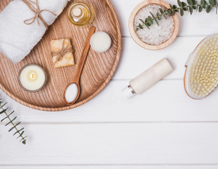 Cosmetics and accessories for body care on the white wooden table.