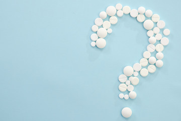 Concept medical of exam, diagnosis and treatment, on blue background with mix pills as question mark