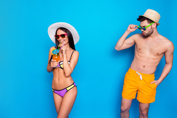 Glance over the glasses. Tanned man looks at the dark haired cute girl in a colorful bikini whistling. Hot summer, beach season - obrazy, fototapety, plakaty