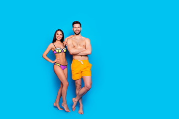 Full-length shot with slim girl in a separate swimsuit laid her hand on shoulder to guy in yellow...