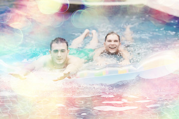 friends have fun in the summer pool at the hotel / cheerful company of young friends of men and women in summer swim in the pool on vacation hotel