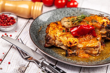 Mexican cuisine, pork or beef steak with a spicy sauce of salsa. with red pepper, marasm and titanium, cherry tomatoes, knife and fork.