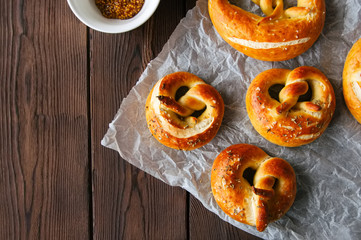 Traditional salted pretzels with oregano over wooden background. Oktoberfest or beer snack concept. Top view and copy space.