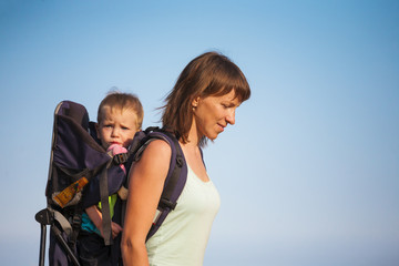  A woman is carrying a backpack with her baby.