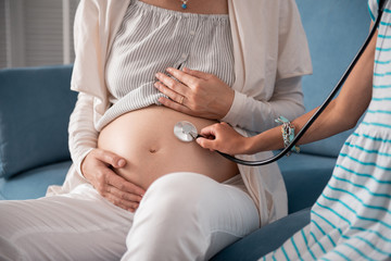 Girl with bracelet. Little girl wearing white and blue dress and blue bracelet holding stethoscope in her hand