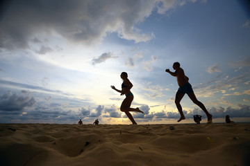 silhouettes of athletes running along the beach / sports summer in the warm sea, healthy rest, sports activity, summer vacation - Powered by Adobe