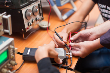 photo man measures voltage tester on an electronic device