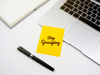 Stop gossiping text on sticky note on work desk