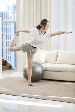 Young Chinese woman practicing yoga at home
