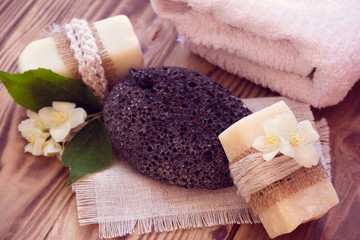 Two pieces of dry soap with a jasmine, towel and pumice