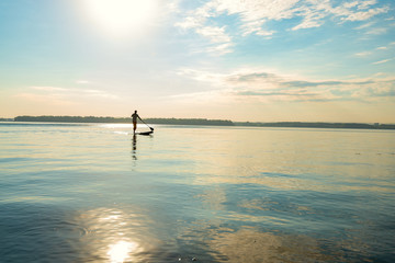 Silhouette of man who is training on a SUP board