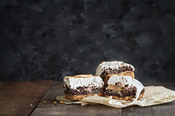 Delicious Smores Peanut Butter Brownie bars with free space for text. Extreme shallow depth of field with selective focus on smores bars in the foreground.
