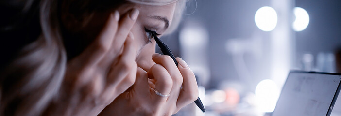 Make-up  narrow frame / make-up on face, the girl is making  make-up in  panoramic frame, girl paints the eyelashes and lips