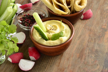 Healthy hummus dip with olive oil and pita bread and vegetables, copy space