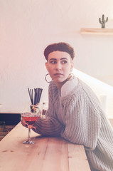 Woman standing near wooden bar with alcohol