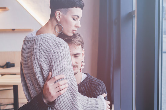 Woman With Bowl Cut Embracing Man In Room Interior