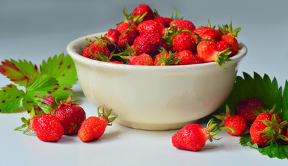 Ripe garden strawberries on a plate on the table. 