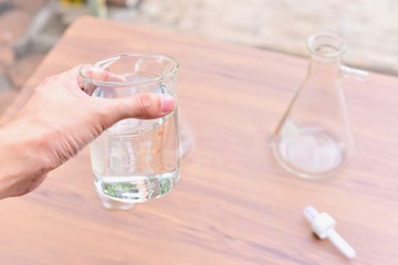 Hand Holing a Laboratory Glass Beaker