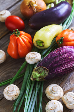 Flat lay eggplant and various vegetables covered by water drops.