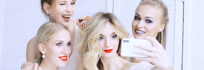 group of models make-up / four girls with professional make-up posing in the studio, a party of beautiful girls friends