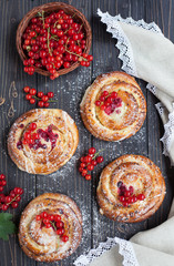 Fresh yeast buns with cheese and berries on wooden background.
