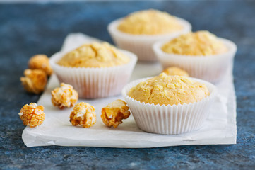 Homemade cornbread muffins on a blue stone background.