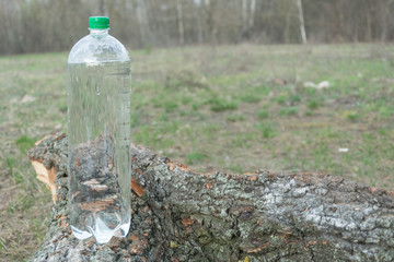 Obraz premium A bottle of water on the ground in a hike in nature.