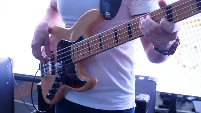 guitarist plays on musical instrument on stage close-up