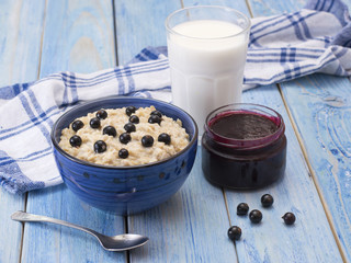 oat porridge with black currant on a blue wooden table. 