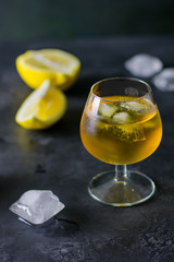 A glass of brandy, ice and lemon