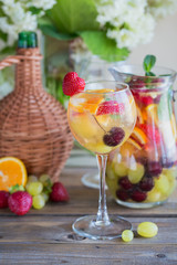 Homemade refreshing fruit sangria or punch with champagne, strawberries, oranges and grapes.