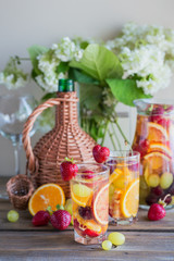 Homemade refreshing fruit sangria or punch with champagne, strawberries, oranges and grapes.
