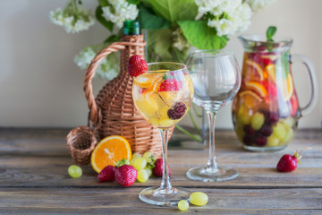 Homemade refreshing fruit sangria or punch with champagne, strawberries, oranges and grapes.