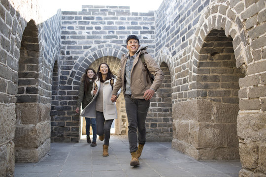 Happy young Chinese friends enjoying winter outing on the Great Wall