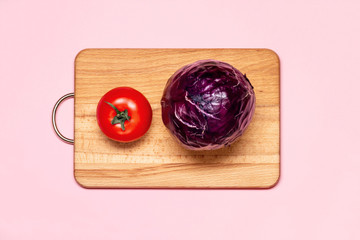 Healthy Eating. One Fresh Tomato Near One Violet Cabbage On A Wooden Chopping Board