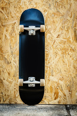 skateboard with white wheels on a wooden background in a skatepark © superelaks