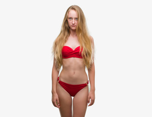 Obraz premium Blonde teenager woman wearing red bikini skeptic and nervous, frowning upset because of problem. Negative person.