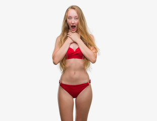 Obraz premium Blonde teenager woman wearing red bikini shouting and suffocate because painful strangle. Health problem. Asphyxiate and suicide concept.