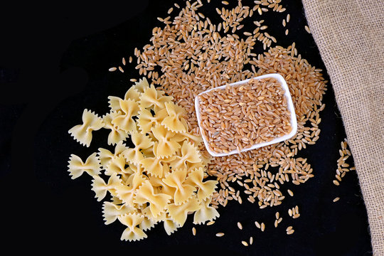 pasta and wheat together on a black background
pasta and wheat side by side,

