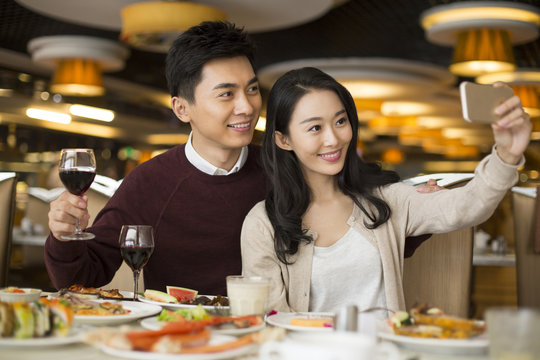 Cheerful young Chinese couple having buffet dinner